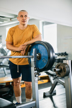 Senior Man Resting After Weightlifting in a Gym