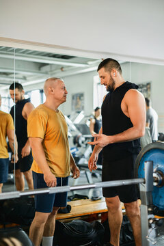Two Men Chatting Happily in a Gym After Workout