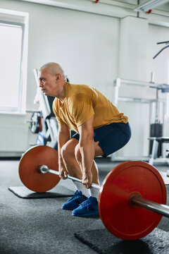 Man performing deadlift exercise with barbell in the gym