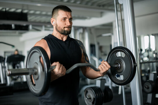 Focused man lifting a barbell during an intense gym workout