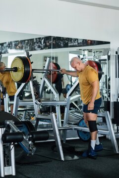 Muscular man resting after a challenging squat session in the gym