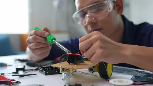 Engineer soldering electronic components on a robot prototype