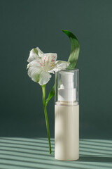 Beige tube with cream on green background with Light on wall with flowers and leaves. A cleansing make-up lotion for clean and fresh skin. Makeup remover in plastic packaging