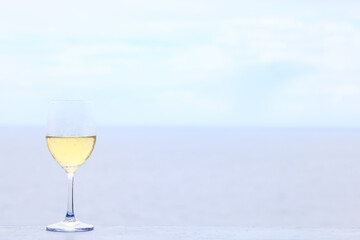 a glass of white wine on the background of the sea relaxing by the sea with wine