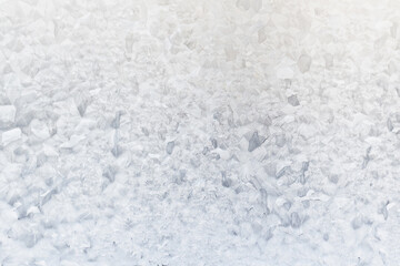 white winter background, frosty patterns on glass, abstract backdrop of ice and snow crystals in a blur