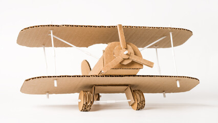 Handmade cardboard biplane on white background, DIY aviation craft © Iana Alter