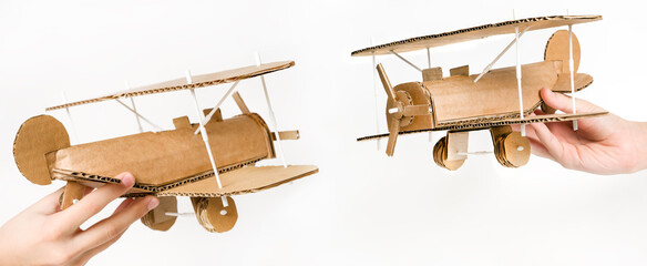 Handmade cardboard biplane in child's hand, different views on white background © Iana Alter