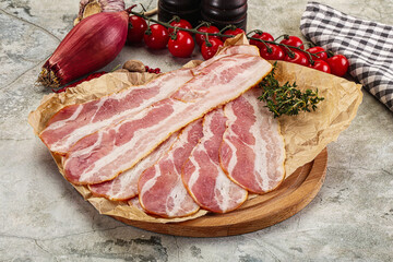 Sliced pork bacon over board