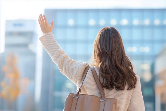 A woman calling for a taxi in a busy downtown area