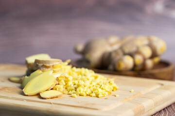 Organic Ginger with Thin Slices and Chopped Pieces on a Rustic Wooden Dish