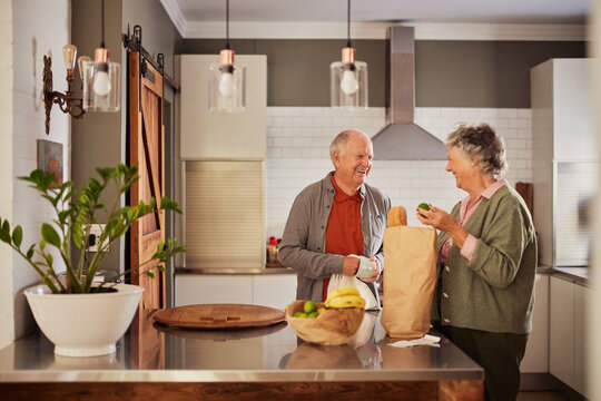 Senior couple sorting vegetables after shopping at grocery shop