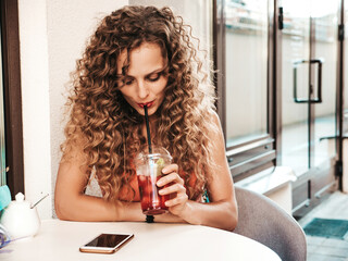 Young beautiful smiling hipster woman with afro curls hairstyle. In summer sport clothes posing in...