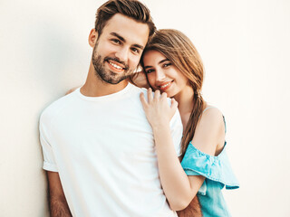 Portrait of smiling beautiful woman and her handsome boyfriend. Woman in casual summer jeans dress. Happy cheerful family. Female having fun. Couple posing on the street background in sunglasses