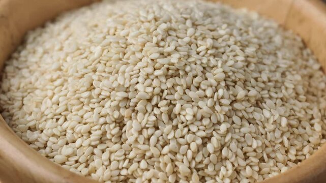 Pour white sesame seeds into a bowl.