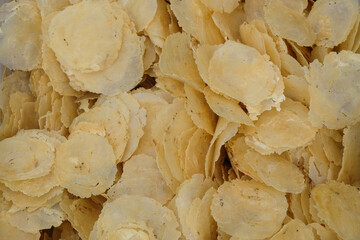 Pile of unfried chips with abstract patterns and textures. Traditional Indonesian food chips made from Gnetum gnemon seeds. Food industry concept. For graphic design, 3D rendering and banner backgroun