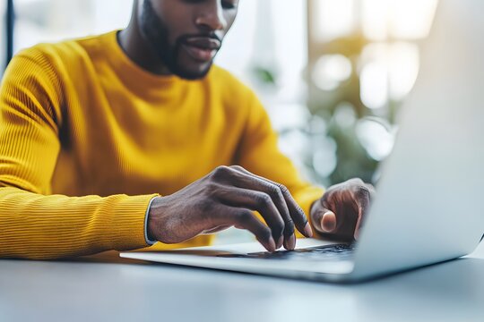 Man using laptop  close up hands  yellow sweater  online work