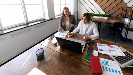 Colleagues collaborate on project analysis in a bright modern office space during midday