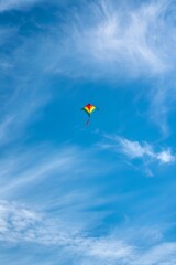 Colorful Kite Soars High in a Clear Blue Sky on a Sunny Day