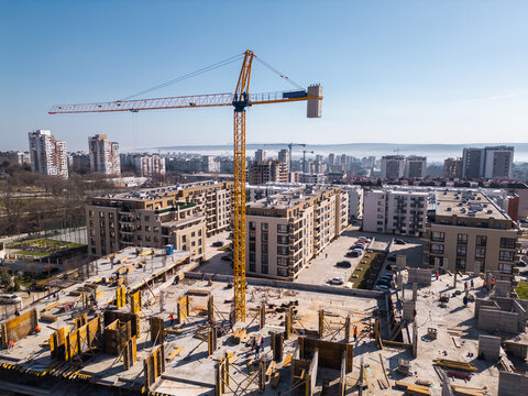 Aerial view of a cityscape with ongoing construction projects and completed residential buildings. Highlights urban development, expansion, and the growth of modern infrastructure