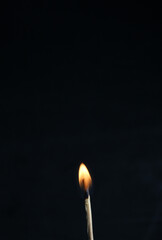 a burning match on a black background,