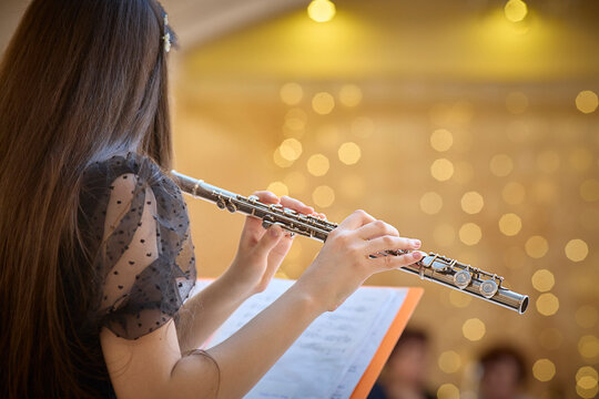 Flute Player Practicing with Sheet Music in Concert Hall. Copy space