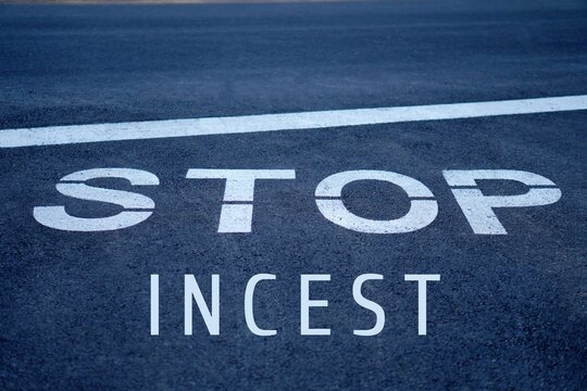 stop incest concept. words written on the asphalt, on a highway stop sign.