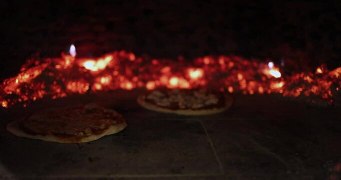 Traditional Pizzas Baking in Rustic Wood-Fired Oven with Glowing Embers