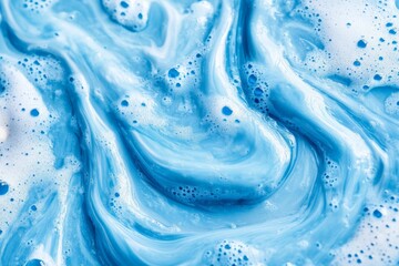 Swirling blue liquid creates captivating patterns in foam and cream