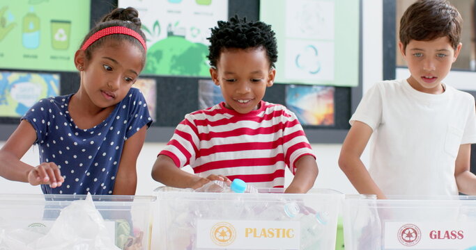 In school, children sorting plastic bottles into recycling bins, learning sustainability