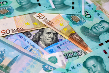 US dollars, Chinese yuan, Euro banknotes and Russian rubles. Concept of trade war between the China and USA, american and european sanctions against Russia