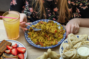 Pierogi z mięsem, tradycyjne gruzińskie himkali z jagnięciną, bogaty stół ze świeżymi owocami 