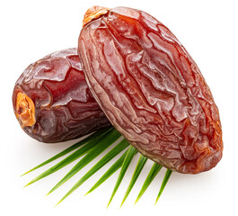 Two semi-dried dates or date palm fruits lie on palm leaves isolated on white background. File...