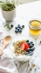 Delicious greek yogurt breakfast with granola and fresh berries on marble surface