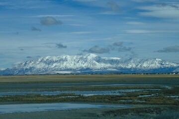 Snow-covered mountains with cloudy sky.