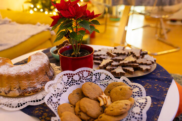 Festive Christmas Table with Cookies, Cake, and Poinsettia in Cozy Holiday Setting