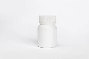 Close up of a plastic white jar with a lid for medicine isolated on a white background