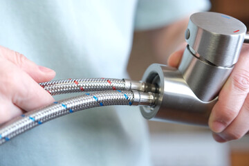 Dismantling of flexible hoses for cold and hot water installed on the mixer. The person unscrews...