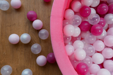 Pink and White Balls in Soft Play Pool on Wooden Surface
