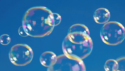 Naklejka premium Bubbles in Blue Sky: A collection of iridescent bubbles floats against a clear blue sky, sparkling in the sunlight and evoking feelings of childhood wonder and freedom.