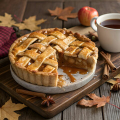 A rustic apple pie with a golden-brown lattice crust, filled with warm, spiced apple filling.