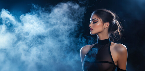 Obraz premium woman in sheer black outfit poses confidently against smoky, dark background, exuding elegance and mystery. Her hair is styled in sleek bun, enhancing her poised demeanor