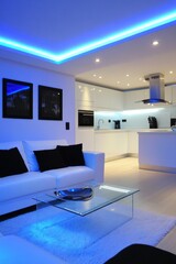 Modern open-plan kitchen living area with blue accent lighting. Interior design