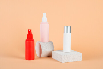 Pink and red blank spray bottle with stylish props on cream background.