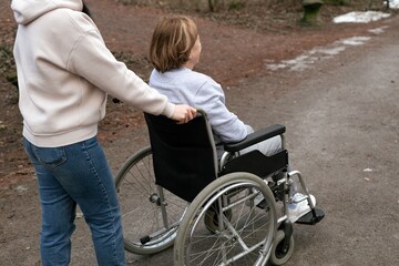 Obraz premium Compassion in Motion Providing Wheelchair Assistance to Individuals in Natures Beauty