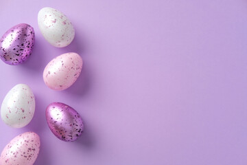 Pastel violet Easter eggs with speckles on a purple background