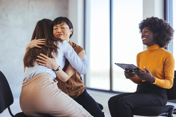 Supportive Group Embracing and Sharing Comfort in a Bright Office Setting