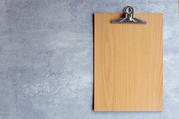 Blank wooden clipboard on modern cement background