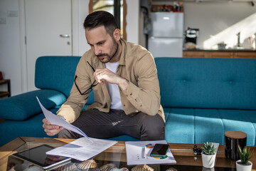 Focused entrepreneur reading documents and planning business strategy at home