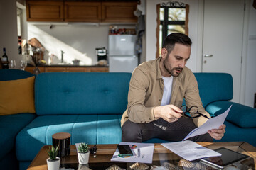 Focused entrepreneur reading documents and working from home office