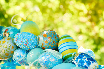 Blue colored spring bouquet of painted Easter eggs on green tree